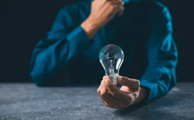 Man holding light bulb and thinking