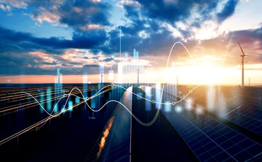 Solar panels and wind turbines in a renewable energy farm at sunset, overlaid with digital graphs and data visualisations, representing clean energy analytics and smart grid technology