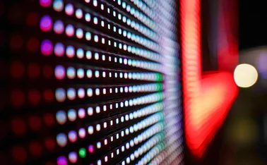 Close-up of colorful LED lights on a digital display screen, creating a futuristic pattern of glowing dots in red, blue, green, and purple, symbolising data visualisation and digital technology