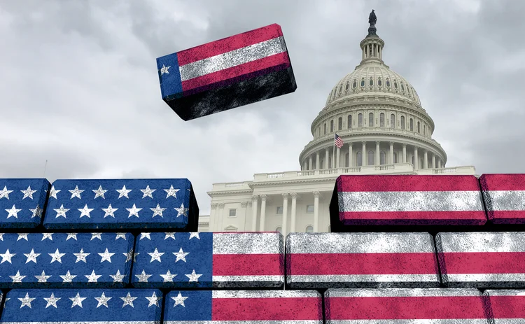 Brick wall being built in front of US govt building with the US flag on them