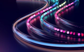 An illuminated, curving tracks suggest speed, adaptability, and continuous progress, while the glowing data-like elements evoke digital communication and technological exchange.
