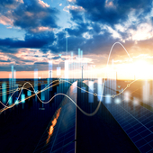 Solar panels and wind turbines in a renewable energy farm at sunset, overlaid with digital graphs and data visualisations, representing clean energy analytics and smart grid technology